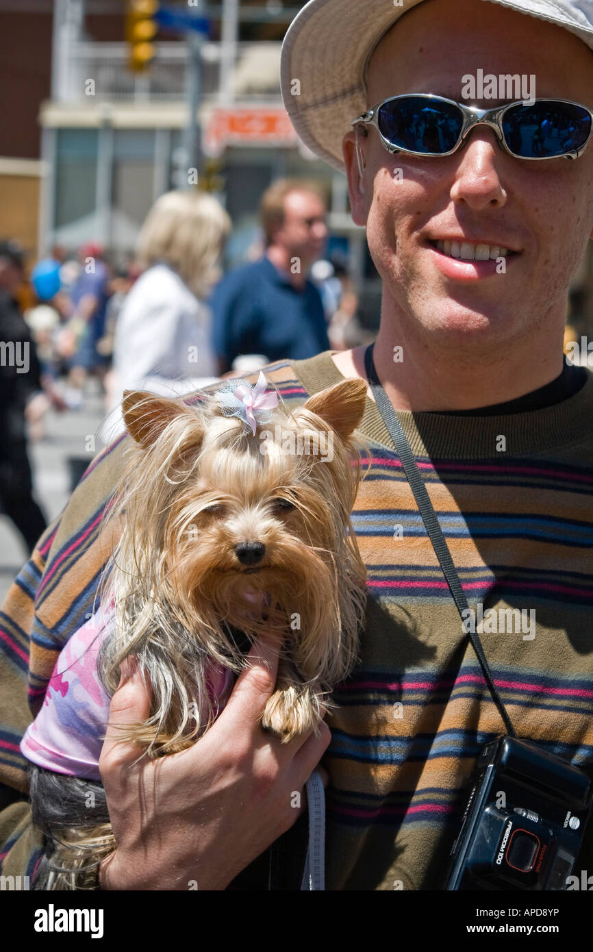 Mann, der Yorkshire-Terrier Hund im Arm hält Stockfoto