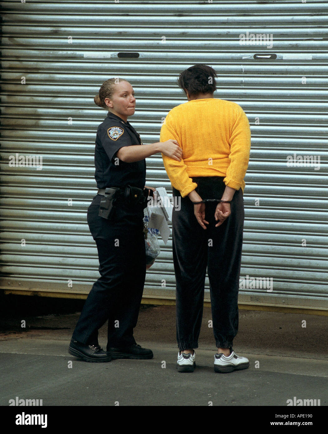 Eine Polizistin NYPD begleitet ein Gefangener in zentralen Bookling Stockfoto