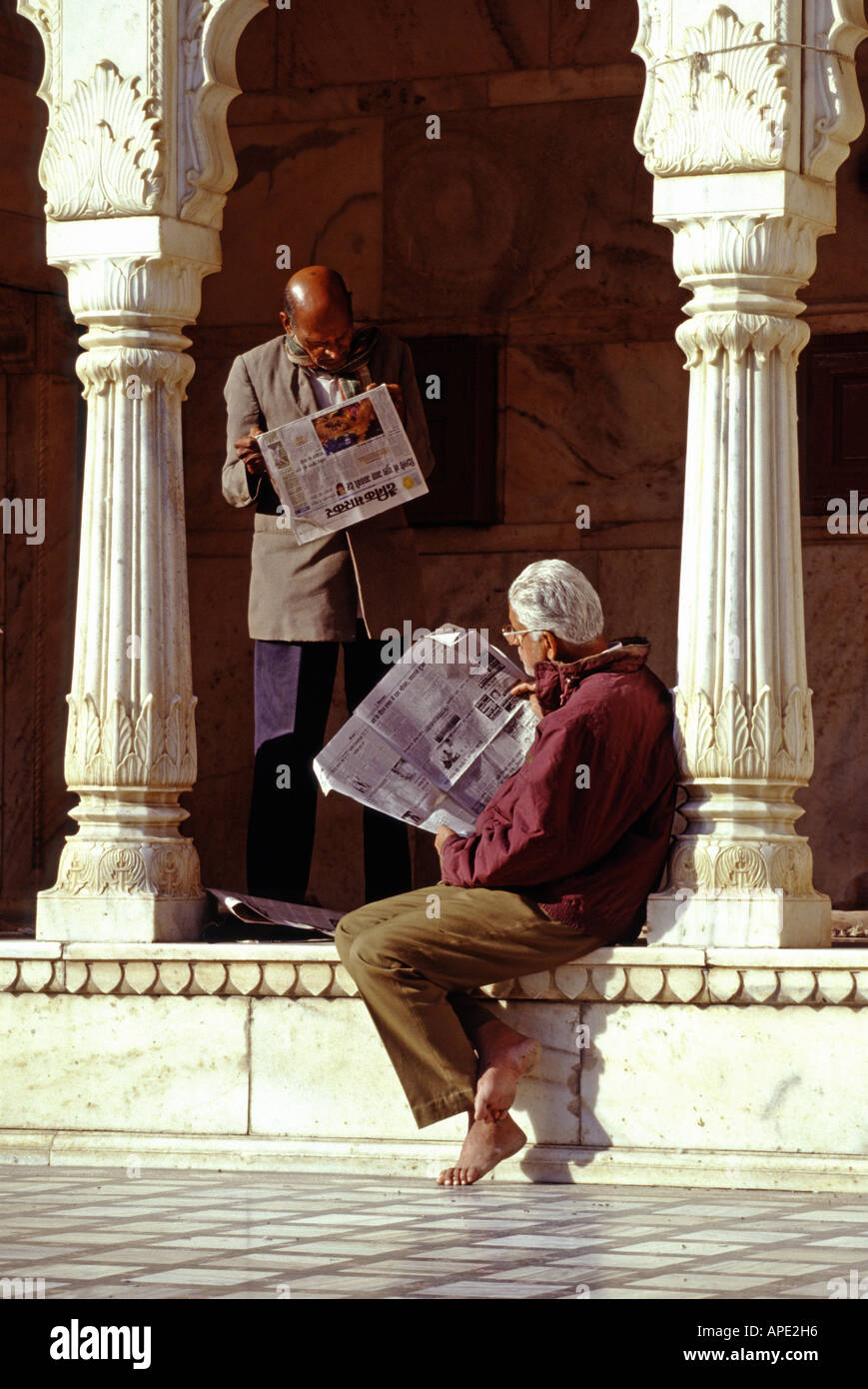 Zwei Männer lesen Zeitungen im Deshnoke Tempel in der Nähe von Bikaner in Rajasthan Indien Stockfoto