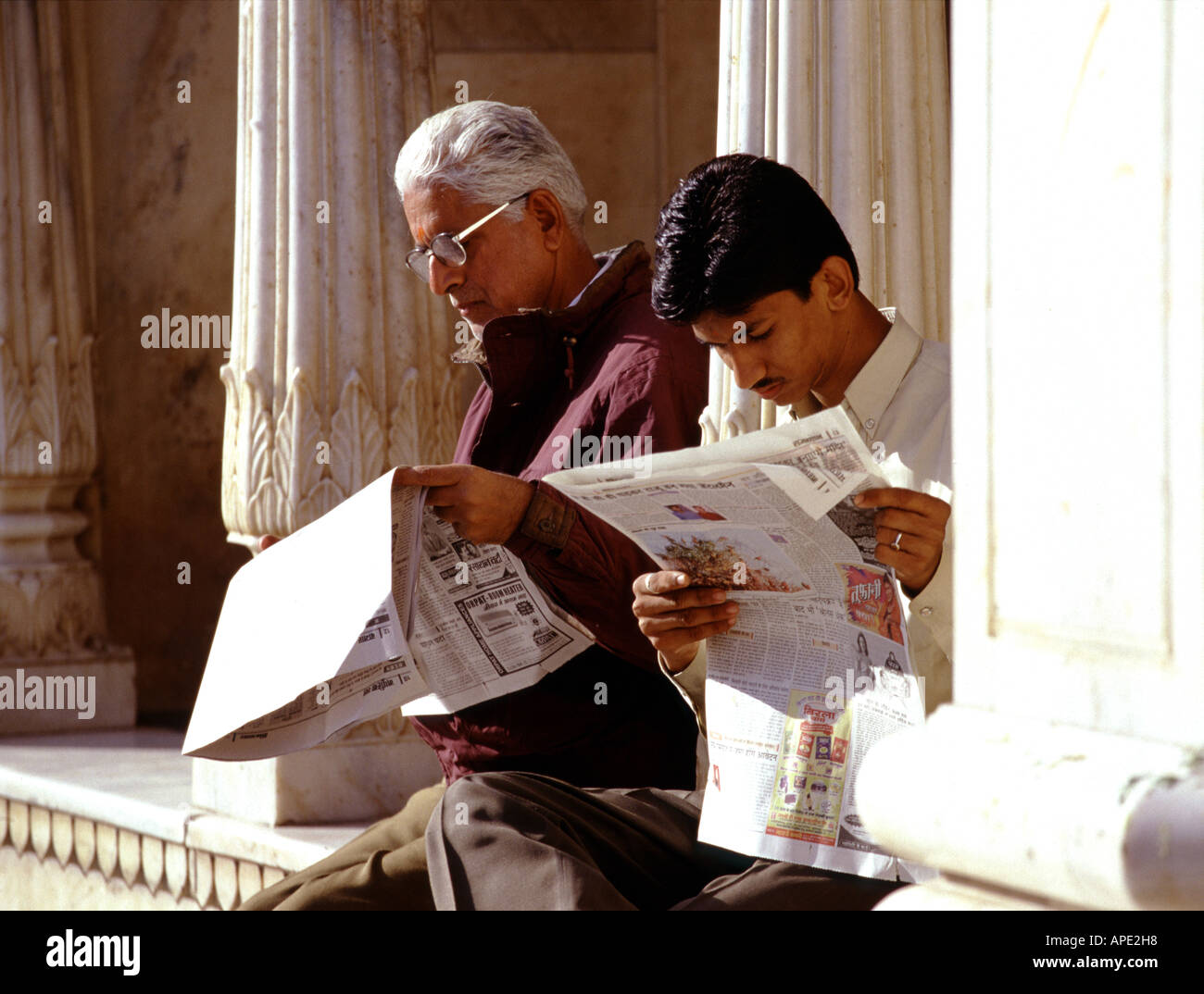 Zwei Männer lesen Zeitungen im Deshnoke Tempel in der Nähe von Bikaner in Rajasthan Indien Stockfoto