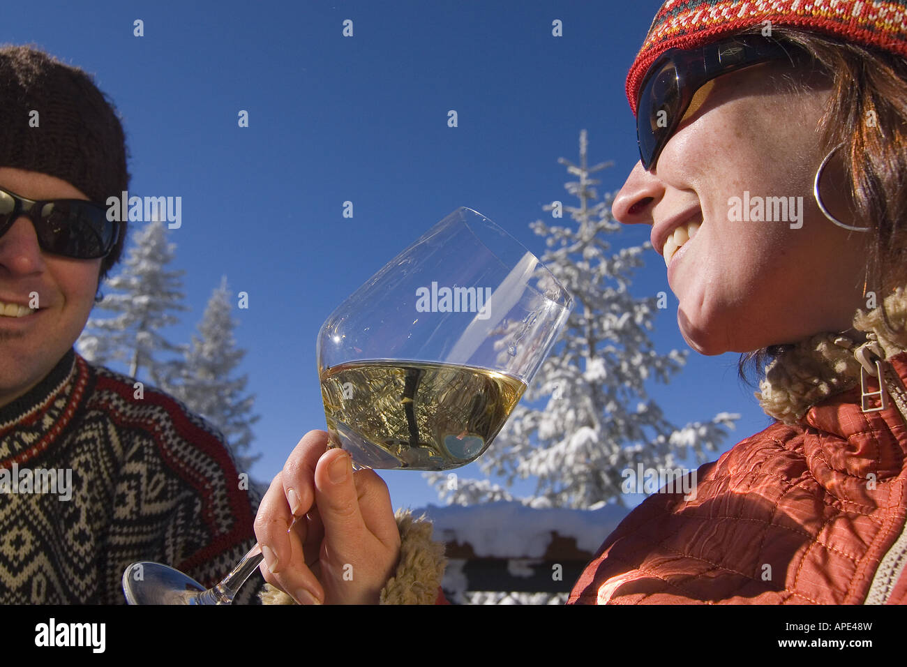 Ein paar trinken Weißwein auf dem Deck eine Ski-Hütte an einem verschneiten Tag im Northstar in der Nähe von Lake Tahoe. Stockfoto