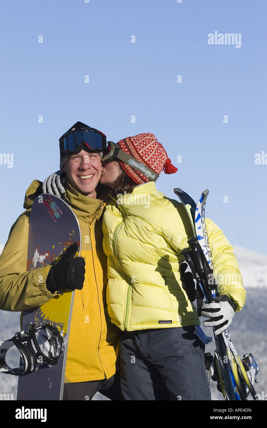 Eine Frau, einem Mann einen Kuss zu geben, beim Skifahren und Snowboarden an einem sonnigen Tag im Northstar Ski Resort in der Nähe von Lake Tahoe. Stockfoto
