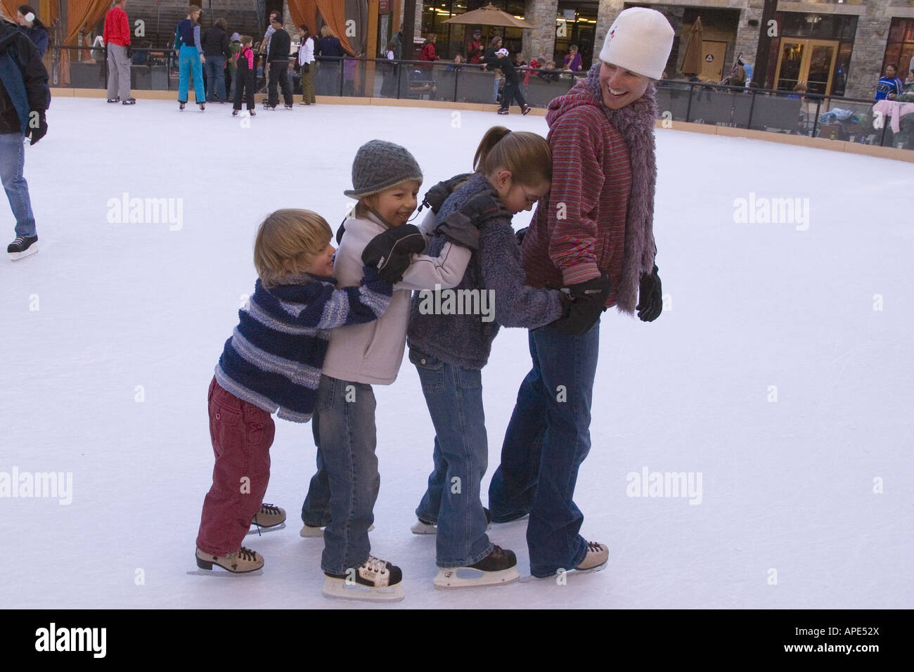 Eine Mutter und drei Kinder Eislaufen in einer Linie mit Northstar-Skigebiet in der Nähe von Lake Tahoe in Kalifornien Stockfoto