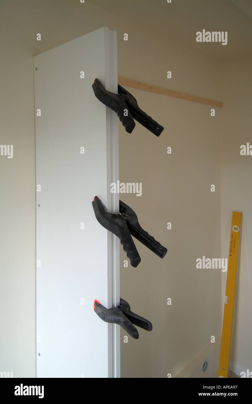 DIY-Projekt im Schlafzimmer Bau Melamin Spanplatte Kleiderschrank Partitionen vor Teppich und Tür hängen mit Leim Schellen Stockfoto
