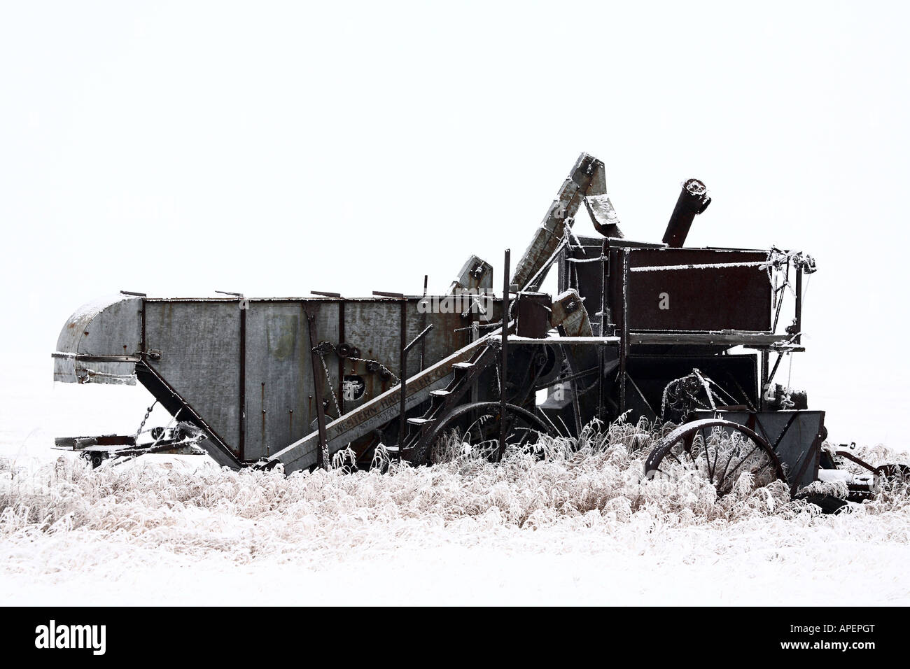 Alte verlassene Dreschmaschine im winter Stockfoto