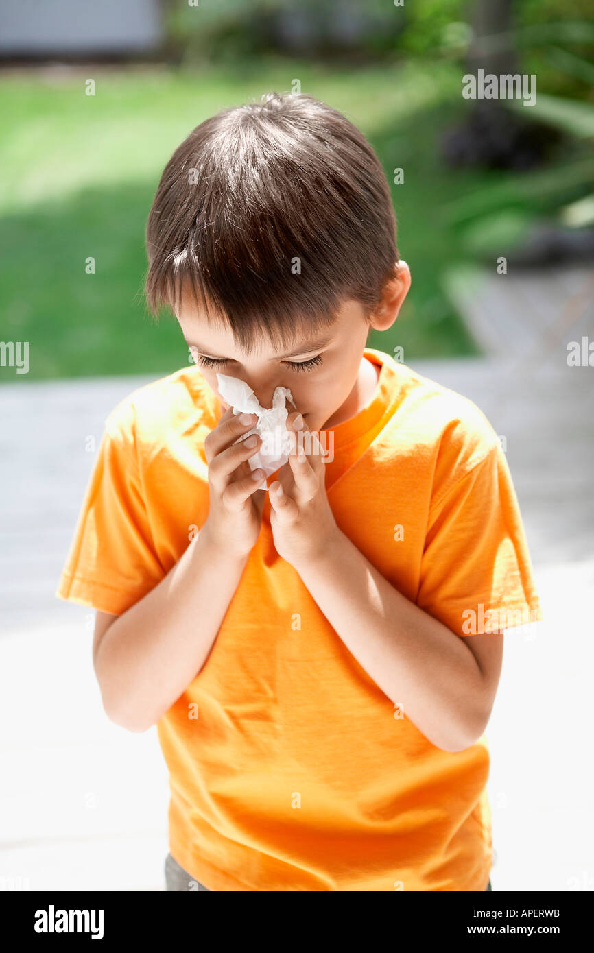 Boy bläst sein Näschen im Hinterhof Stockfoto