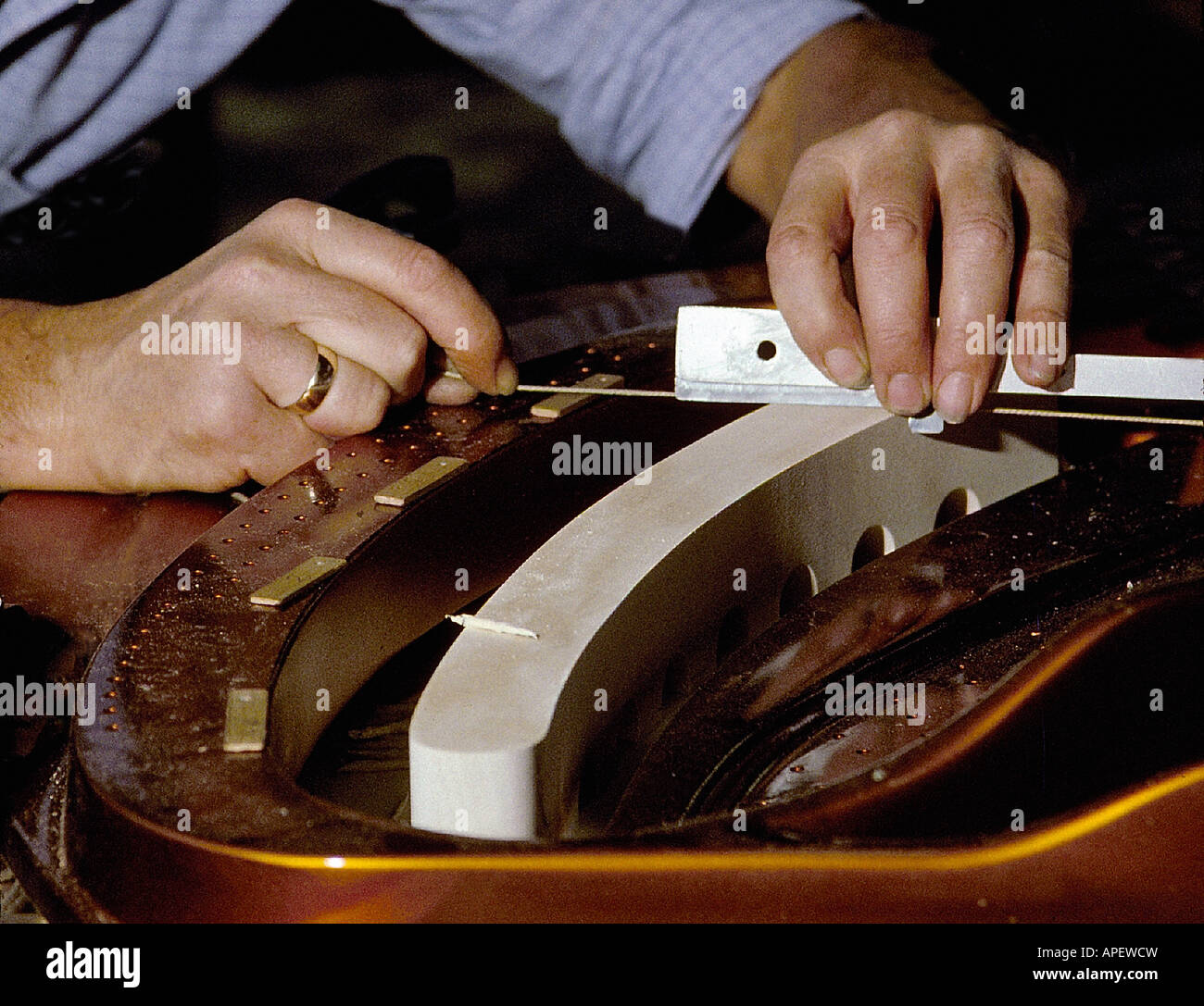 Der Klaviertechniker Hände Nahaufnahme ausrichten Zeichenfolge im Klavier-Frame. (bei Bösendorfer Klavierfabrik, Wien, Österreich). Stockfoto