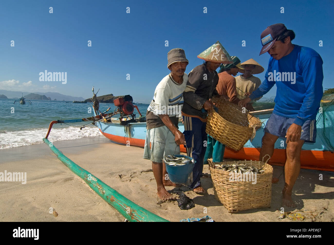 Indonesische Fischer in der Nähe von ihrem Boot und Fischernetze, an einem Strand im östlichen Teil der Insel Java, Indonesien. Stockfoto