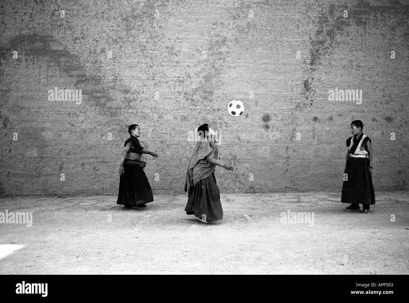 Xiahe-Mönche der Gelben Hutsekte spielen Fußball in der Volksrepublik China der Provinz Xiahe Gansu. Stockfoto