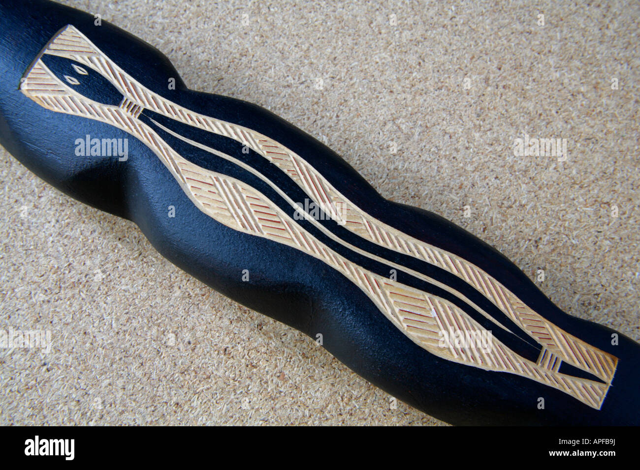 Traditionellen australischen Aborigines primitiver Kunst Holzschnitzerei symbolische Schlange Figur auf geschnitzten Schlange Stick. Stockfoto