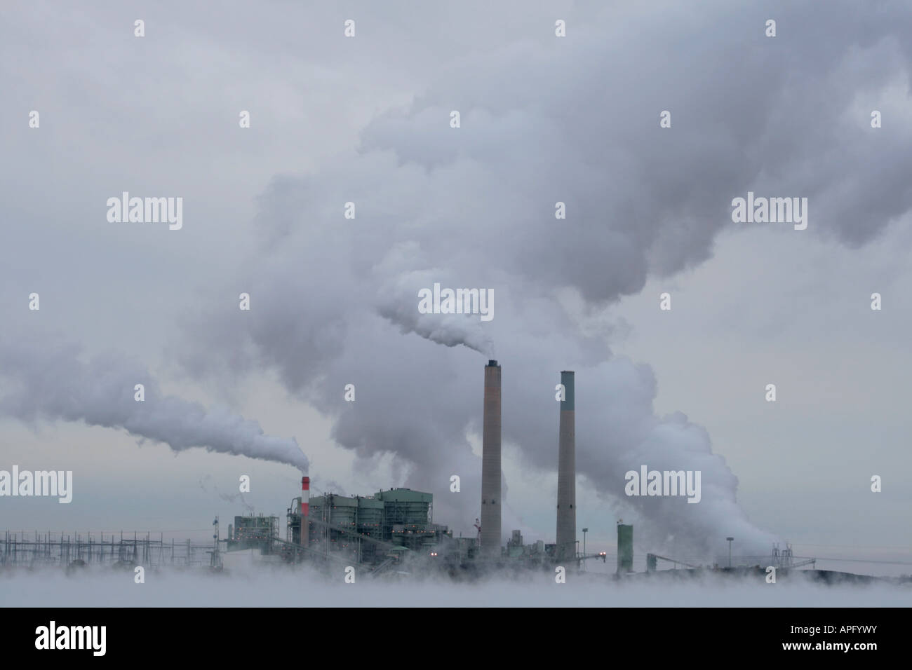 Cholla Kohle befeuerten Kraftwerk produziert Rauch und Dampf an einem kalten bewölkten Tag mit Nebel aus die Kühlbecken verdeckt den Boden Stockfoto