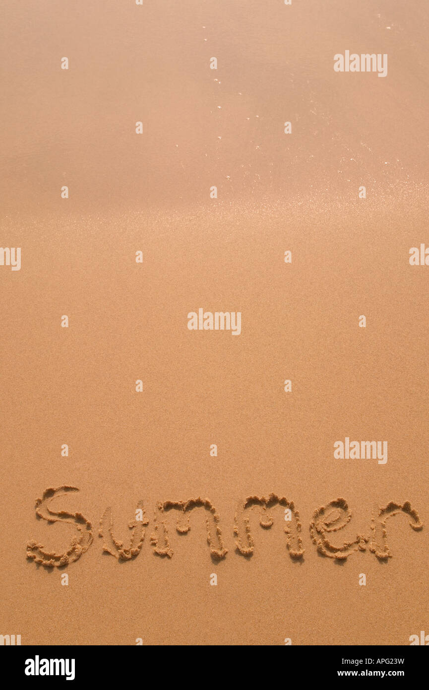 Sommer in goldenem Sand geschrieben, wie die glitzernden Wellen an der Spitze des Rahmens zurücktreten Stockfoto