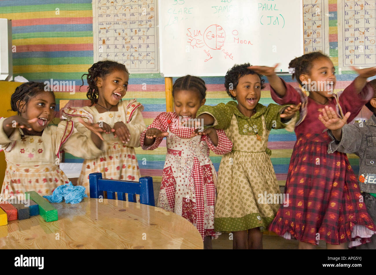 Kinder singen ein Lied mit Aktionen auf die Worte in der Klasse von einem Sponsorenlauf Schule. Stockfoto