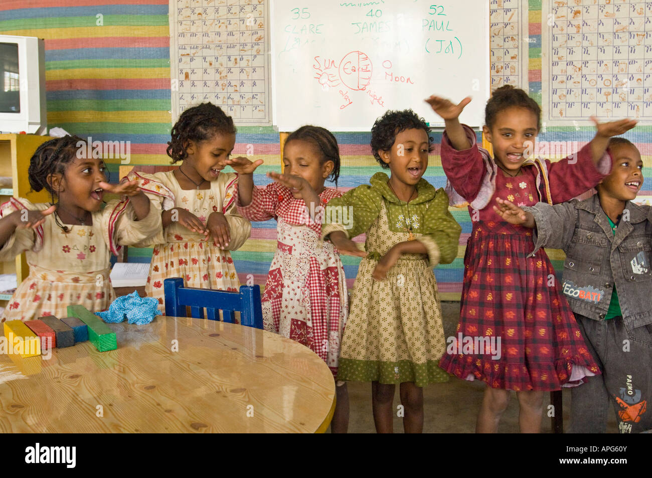 Kinder singen ein Lied mit Aktionen auf die Worte in der Klasse von einem Sponsorenlauf Schule. Stockfoto