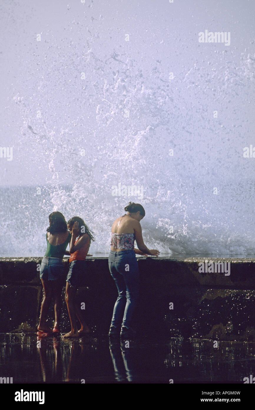 Wellen, die auf Mädchen, Malecon, Havanna, Kuba Stockfoto