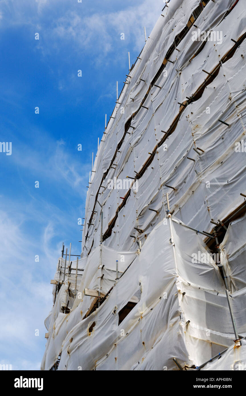 Gerüste und Plastikplanen umgibt ein neues Apartment Komplex im Bau. Stockfoto