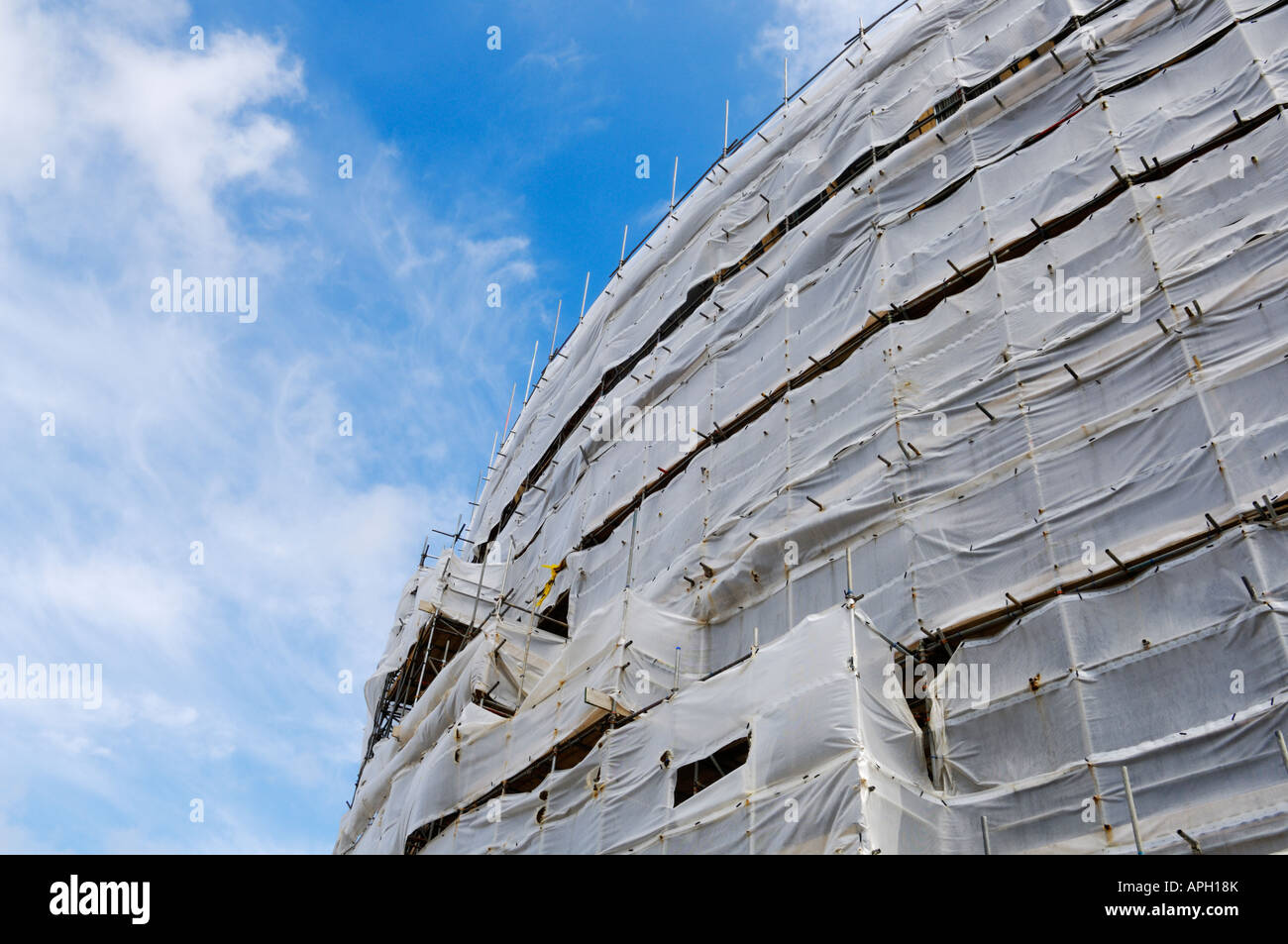 Gerüste und Plastikplanen umgibt ein neues Apartment Komplex im Bau. Stockfoto
