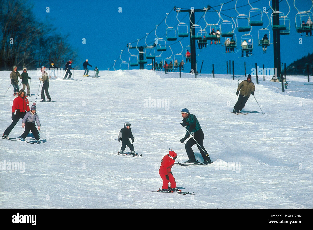 Kleinkinder und Anfänger Skifahren auf den sanften hängen unter den obenliegenden Sessellift auf einem der Berge in den Urlaub und Skizentrum von Stowe Stockfoto
