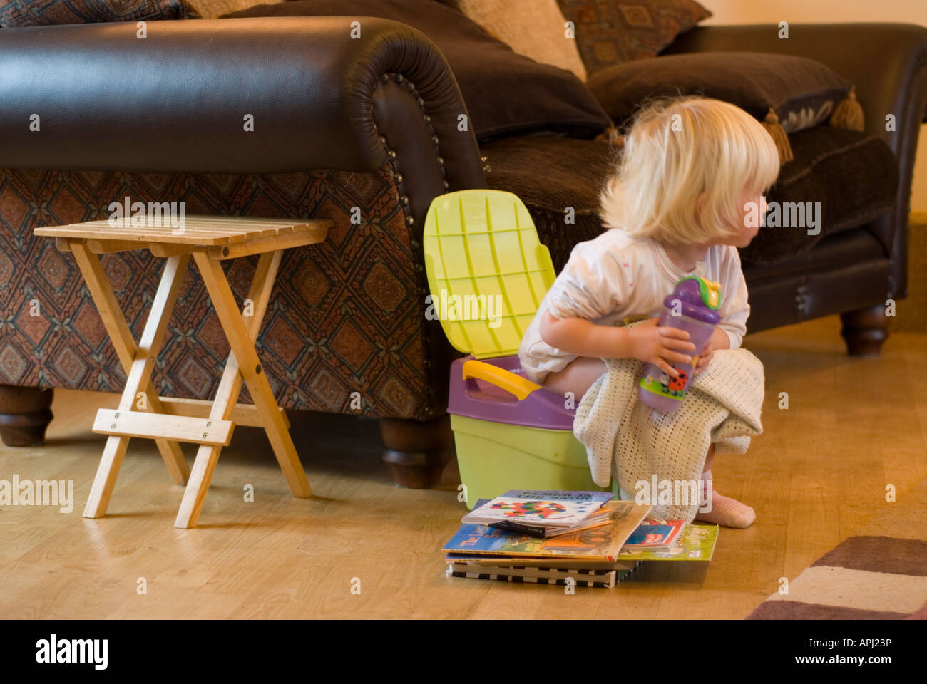Stock Foto eine zweijährige auf ihr Töpfchen Töpfchentraining für ihr bedeutet, dass einen guten Haufen Bücher lesen neben ihr zu sitzen Stockfoto