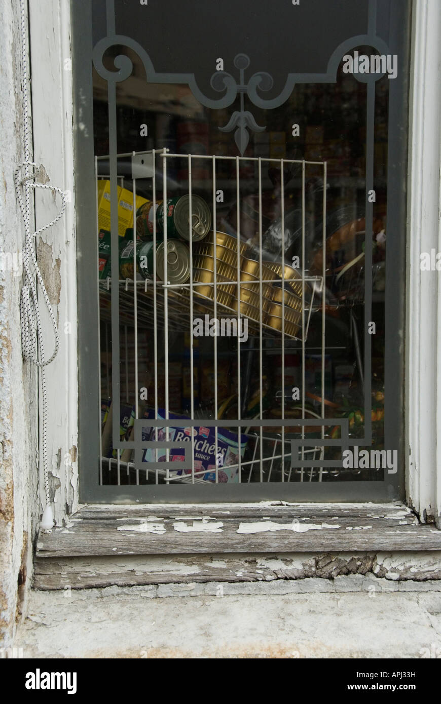 Stock Foto von einem alten Schaufenster mit abblätternde Farbe Insiode laden an der Ecke sehen Sie die Dosen von Lebensmitteln gestapelt zu verkaufen Stockfoto