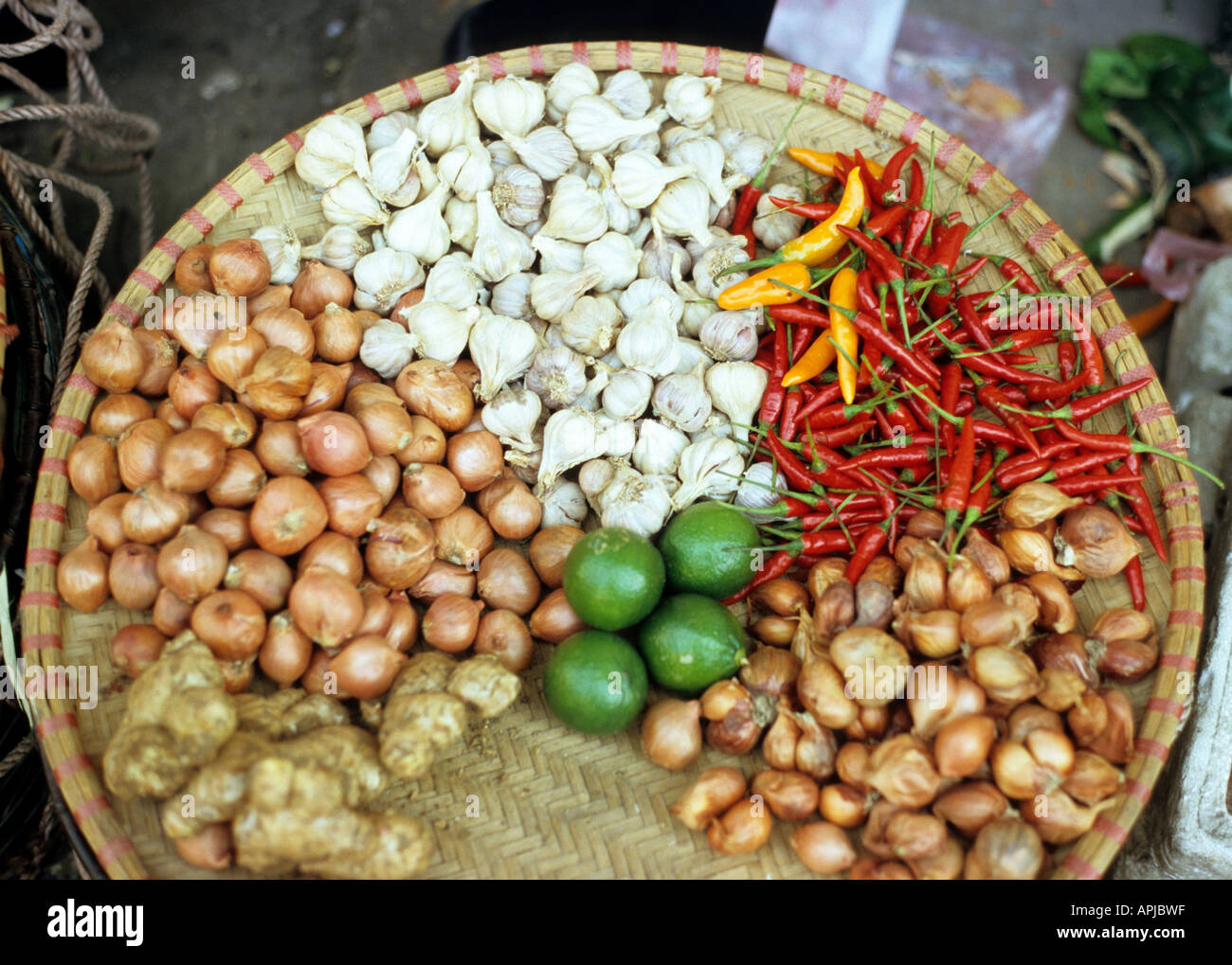 Zwiebeln, Chili, Knoblauch, Ingwer und Limetten in einem Korb an der Gia Ngu St Markt, Altstadt in Hanoi, Vietnam Stockfoto