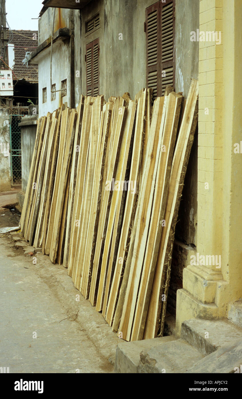 Gewürzt Schnittholz für Tischlerkunst eine Wand gelehnt, Dai Nghiep Möbel Dorf, Hanoi, Vietnam Stockfoto