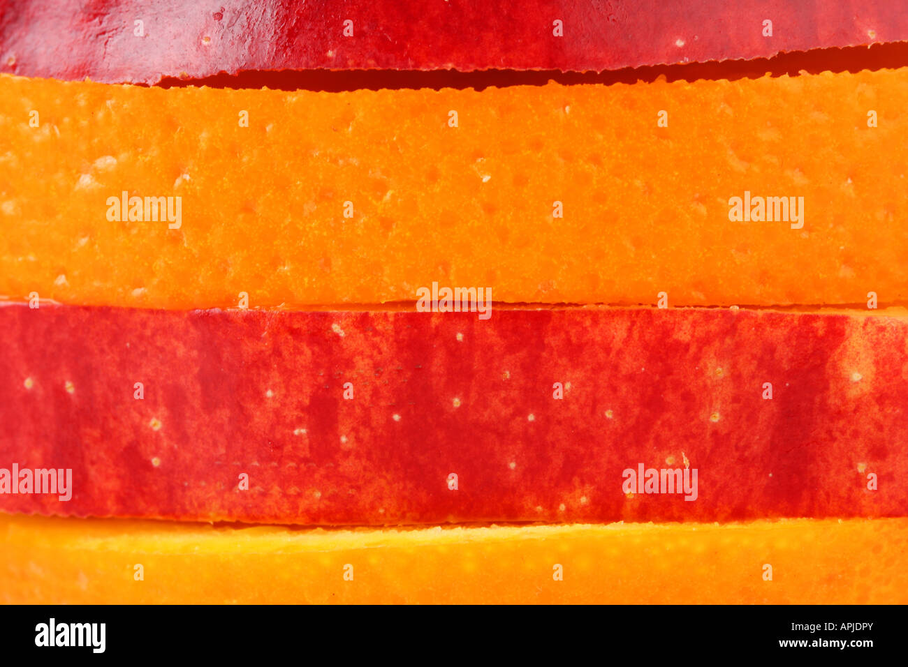 Scheiben vom Apfel und Orange zu bunten Streifen Form zusammenstellen Stockfoto
