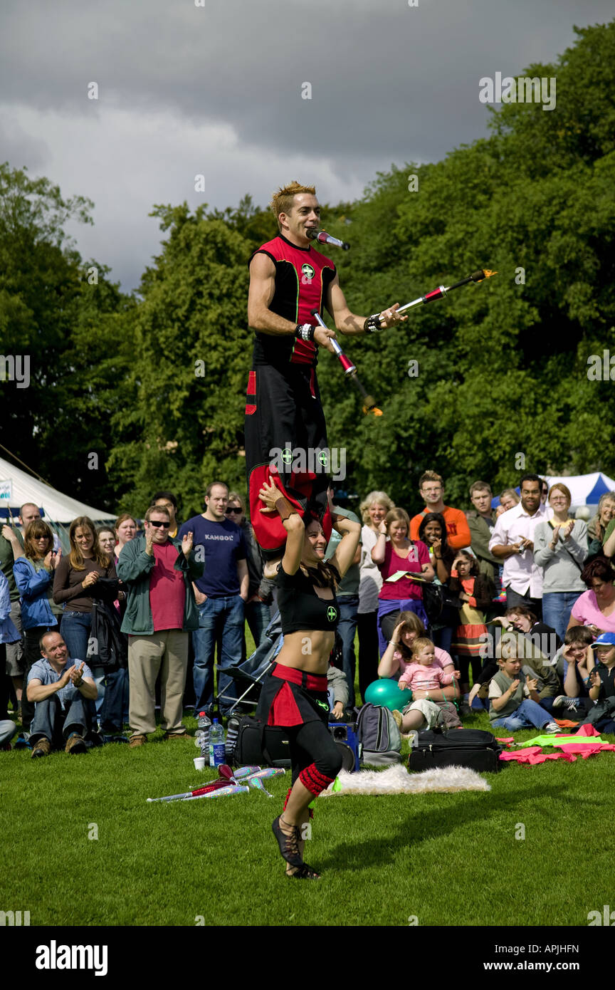 Männliche balancieren auf Weibchen Schultern, während das Jonglieren Feuer Fackeln, Edinburgh Festival Fringe Sonntag, Schottland, UK, Europa Stockfoto