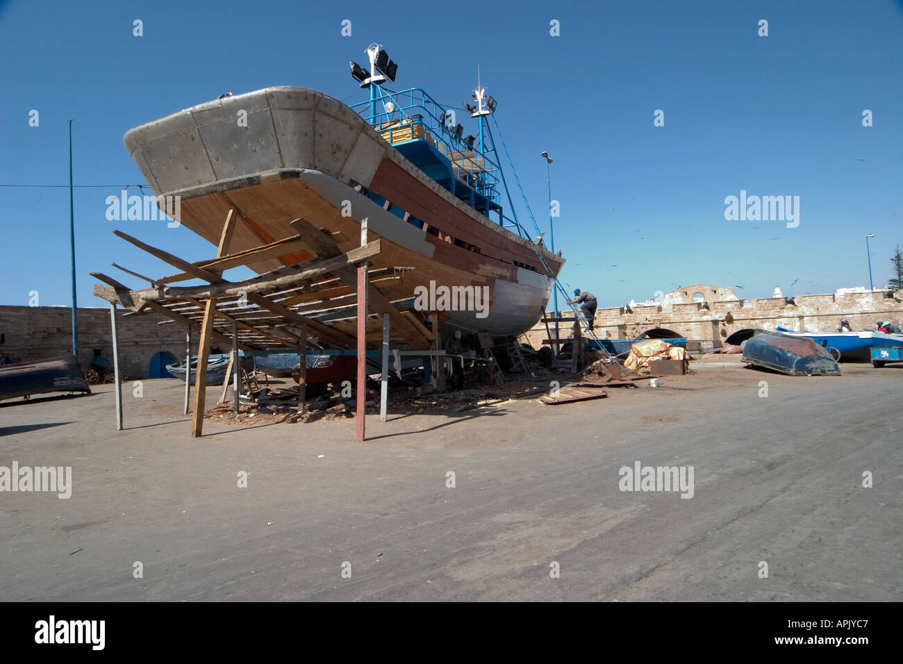 Weitwinkeleinstellung des traditionellen hölzernen Angeln Boot Neariing Abschluss mit kleinen Sardinen Boote im Hintergrund Stockfoto