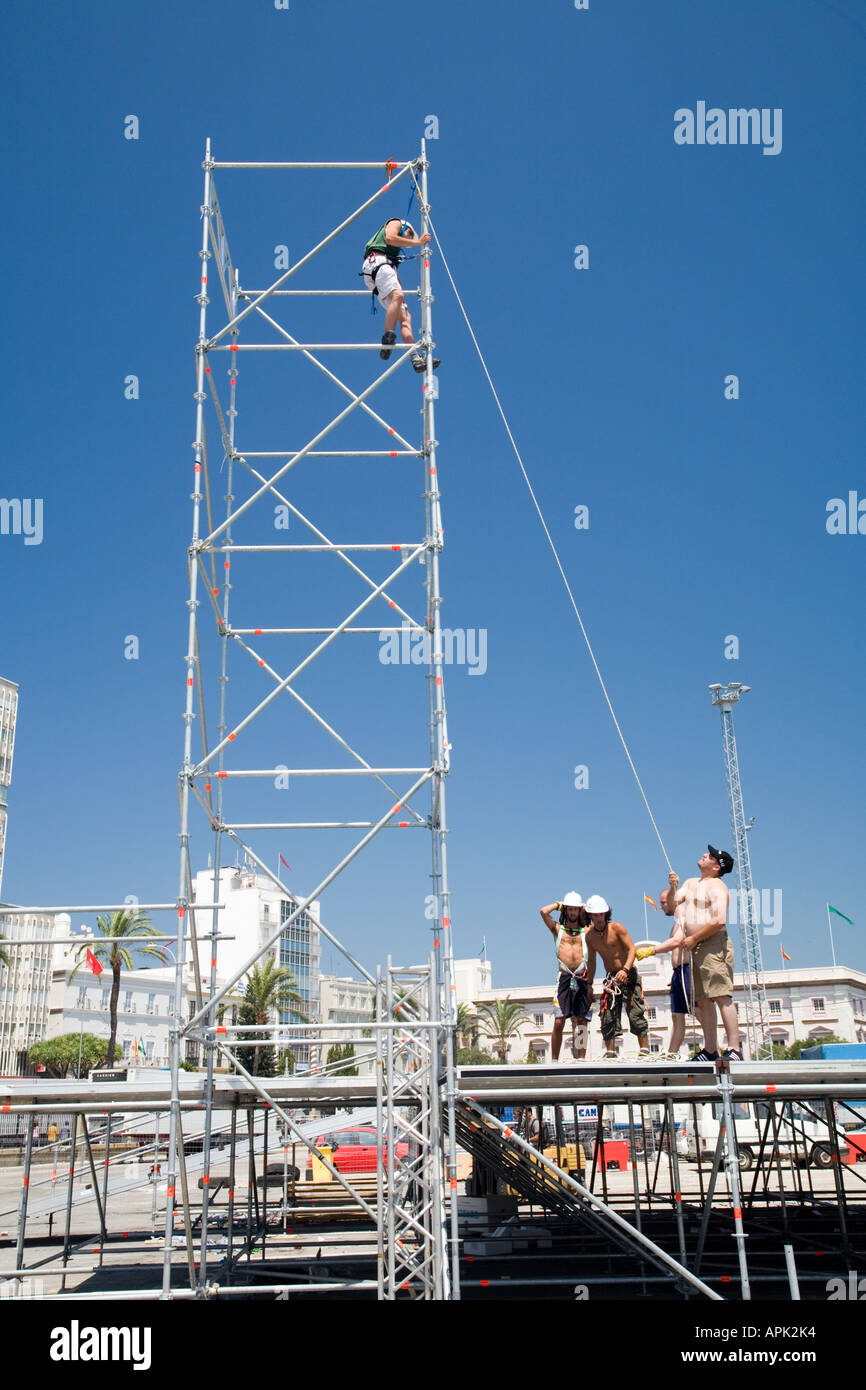 Mann bei der Arbeit auf einem Gerüst vor einem strahlend blauen Himmel Stockfoto