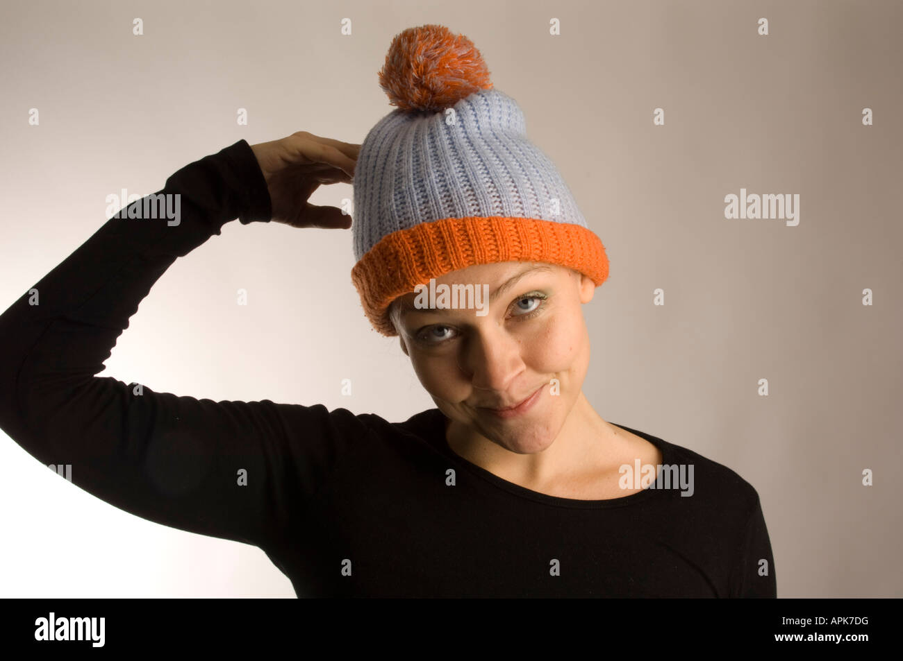 Goofy aussehende Frau im Studio trägt Wollmütze kratzen Kopf in Verwirrung Stockfoto