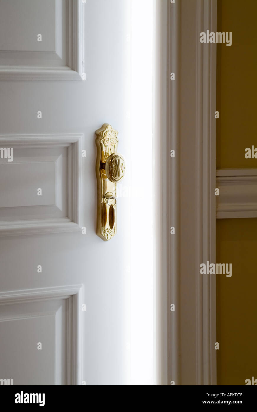 Weiße Tür mit ausgefallenen Gold Türklinke öffnen leicht hellen weißen Raumlicht Stockfoto