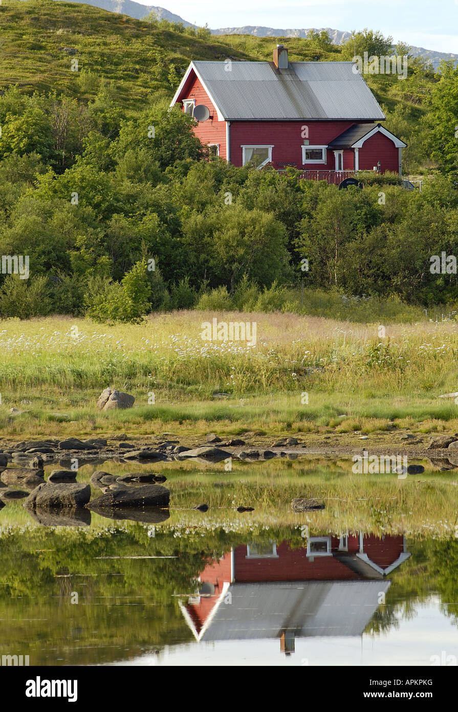 in der Regel rot gefärbt Skandinavisches Haus an einem kleinen See auf Vetsvagoy reflektiert in einem Fjord, Norwegen, Lofoten-Inseln, Vetsvagoy Stockfoto