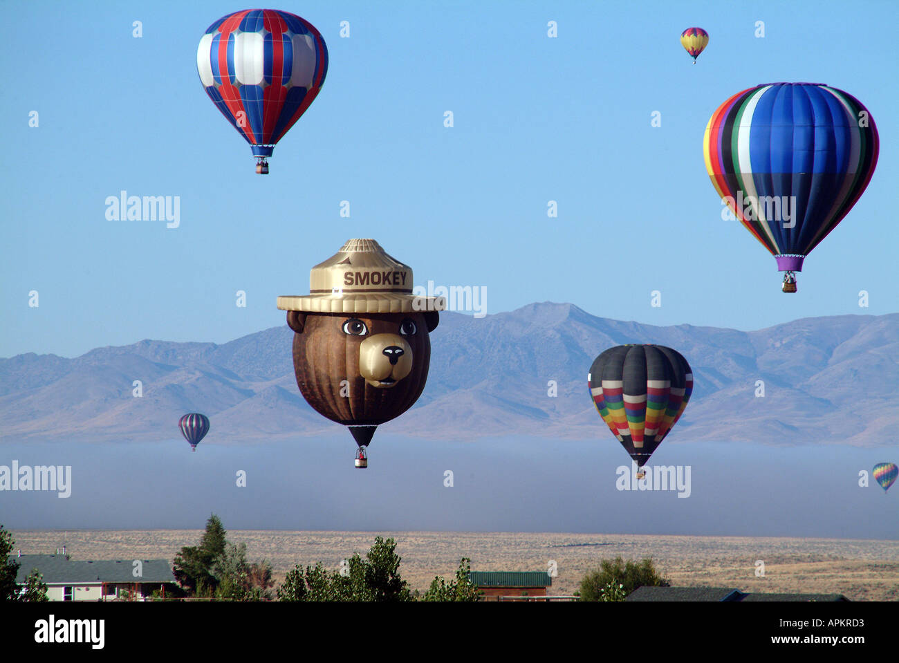 Smokey Bär und seinen Begleitern des Regenbogens Heißluftballons in Nevada Almfest Ruby Segeln über Wüste in der Nähe von Elko, Nevada Stockfoto