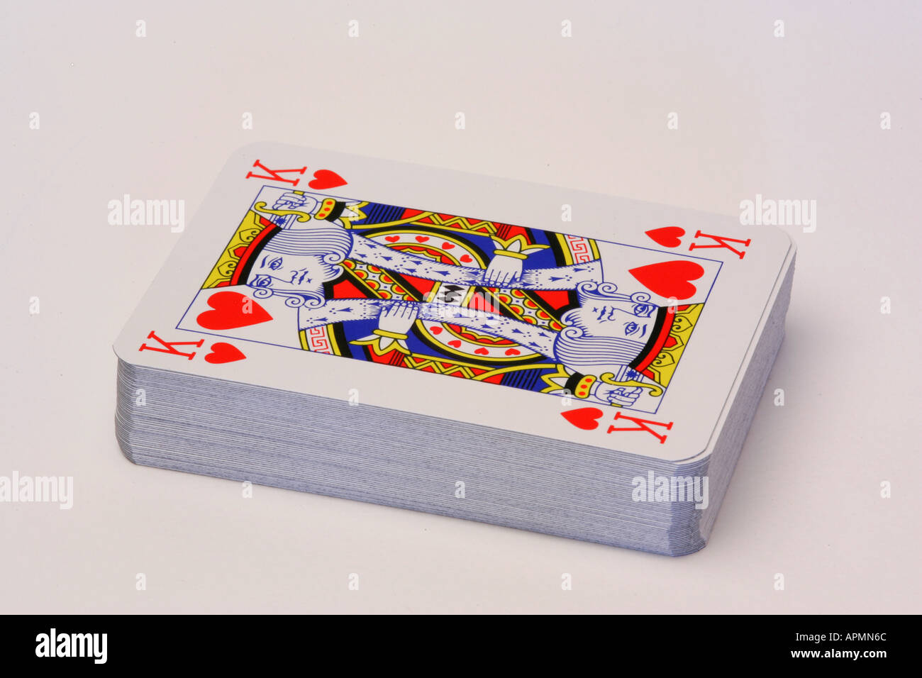 Neues Pack Kartenspiel mit King of Hearts stellen oben auf den Stapel mit weißem Hintergrund Stockfoto