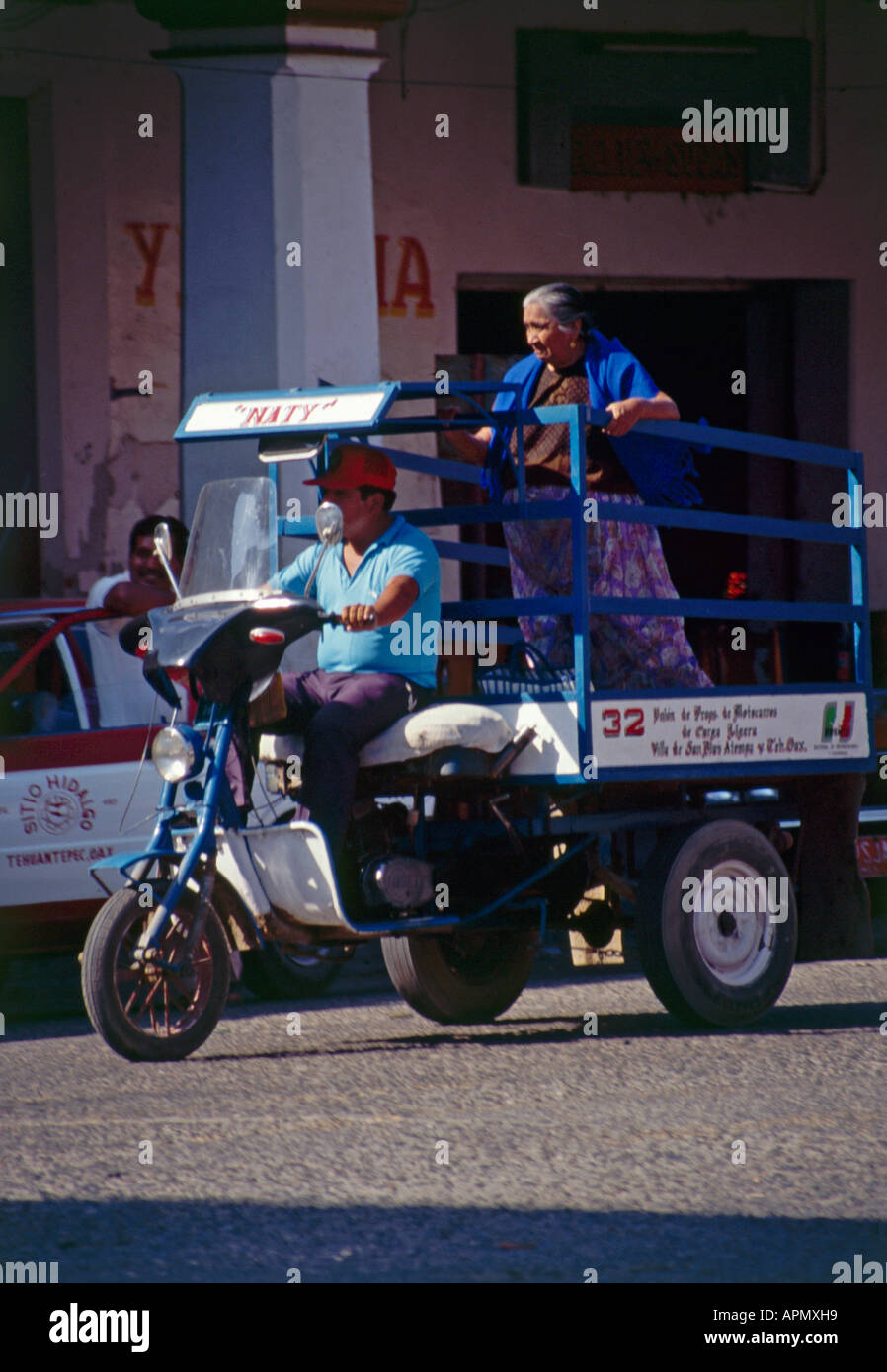 Eine Frau, die Motorradfahren auf der Rückseite ein Motocarro befestigt ein Tiefbett und die wichtigste Form des Nahverkehrs in der Stadt von Tehuantepec Stockfoto