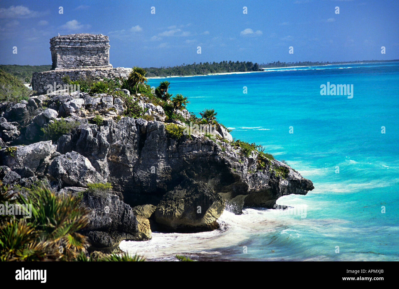 Die ummauerten Ruinen von Tulum angesiedelt zwischen AD 900 1500 während des Post Classic festgelegt auf einem zerklüfteten Felsen mit Blick auf das glitzernde türkisfarbene Wasser der Karibik mit weißen Wellen an der felsigen Küste unten gekappt Stockfoto