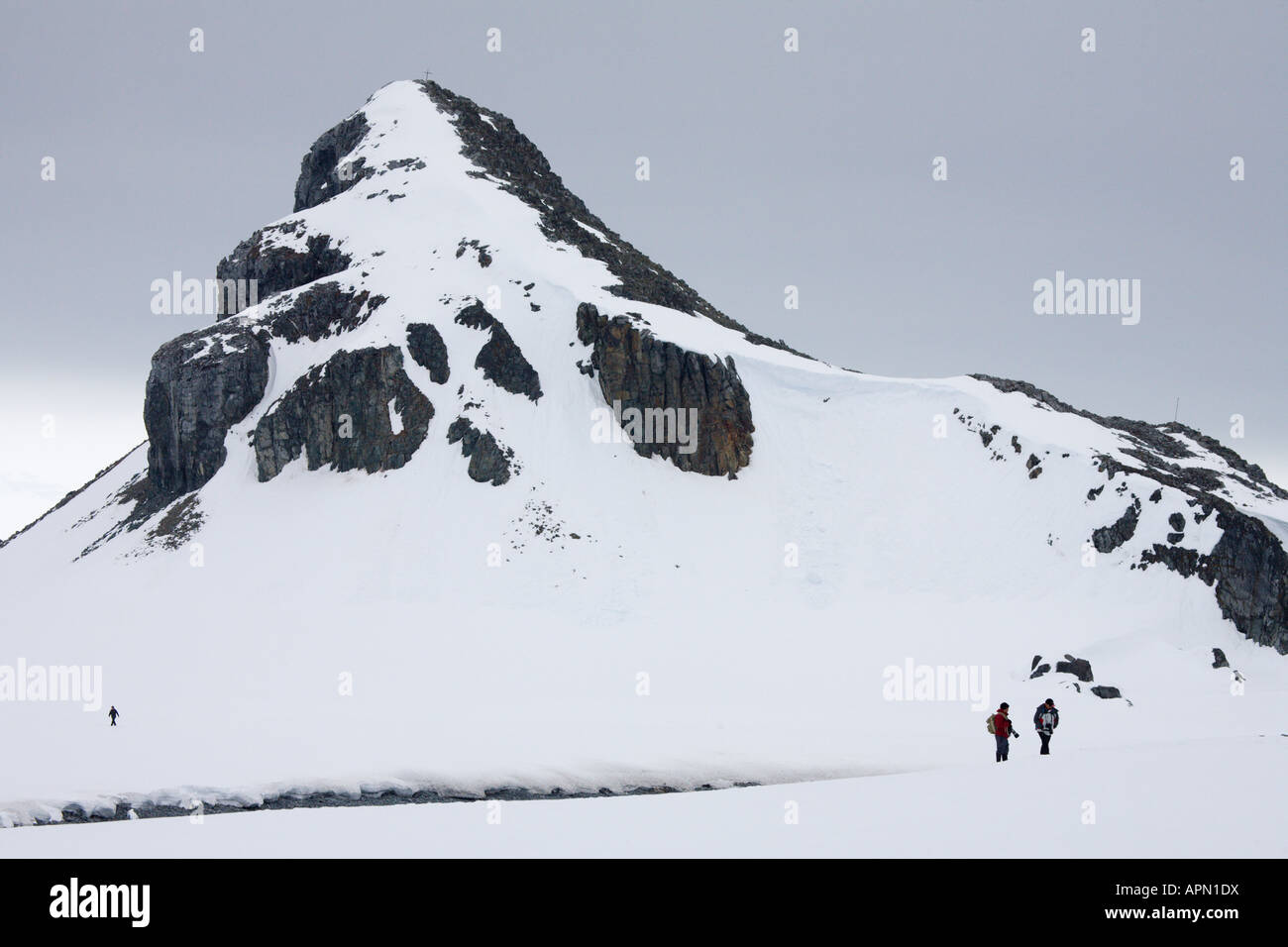 Schneebedeckte Berge und Touristen, Half Moon Island, Antarktis Stockfoto
