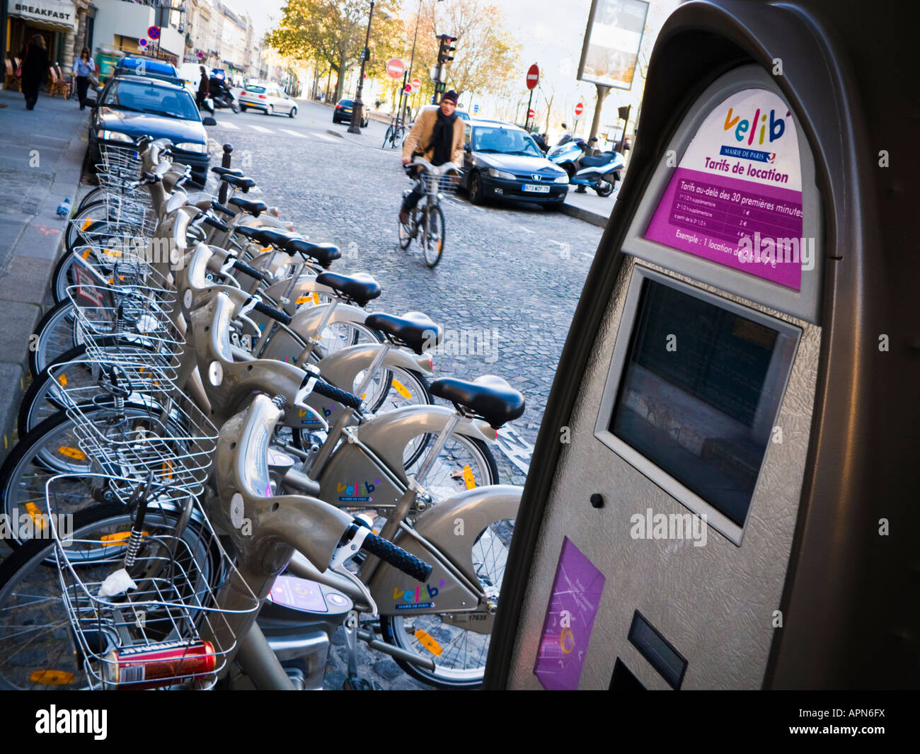 Man Radfahrer auf einem gemieteten Fahrrad Velib in Richtung der Zyklus Rack und Pay station in Paris, Frankreich, Europa Stockfoto