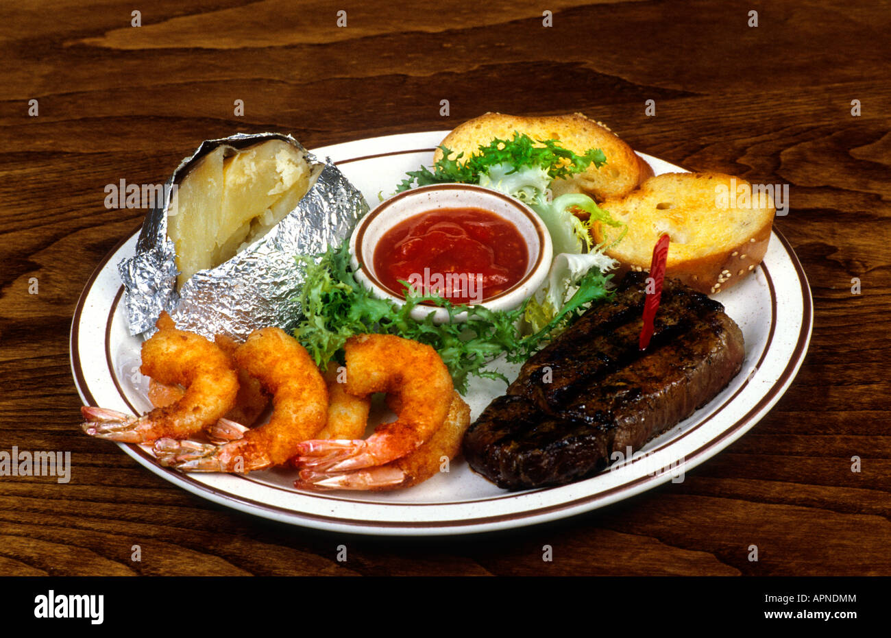Nahaufnahme von Abendessen mit Steak und Garnelen und Kartoffeln im ...