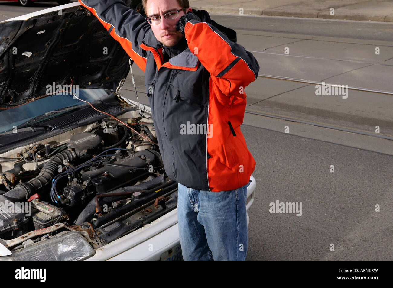 Mann bei offener Motorhaube mit Motorschaden Pannenhilfe auf einem Handy Toronto gefordert Stockfoto
