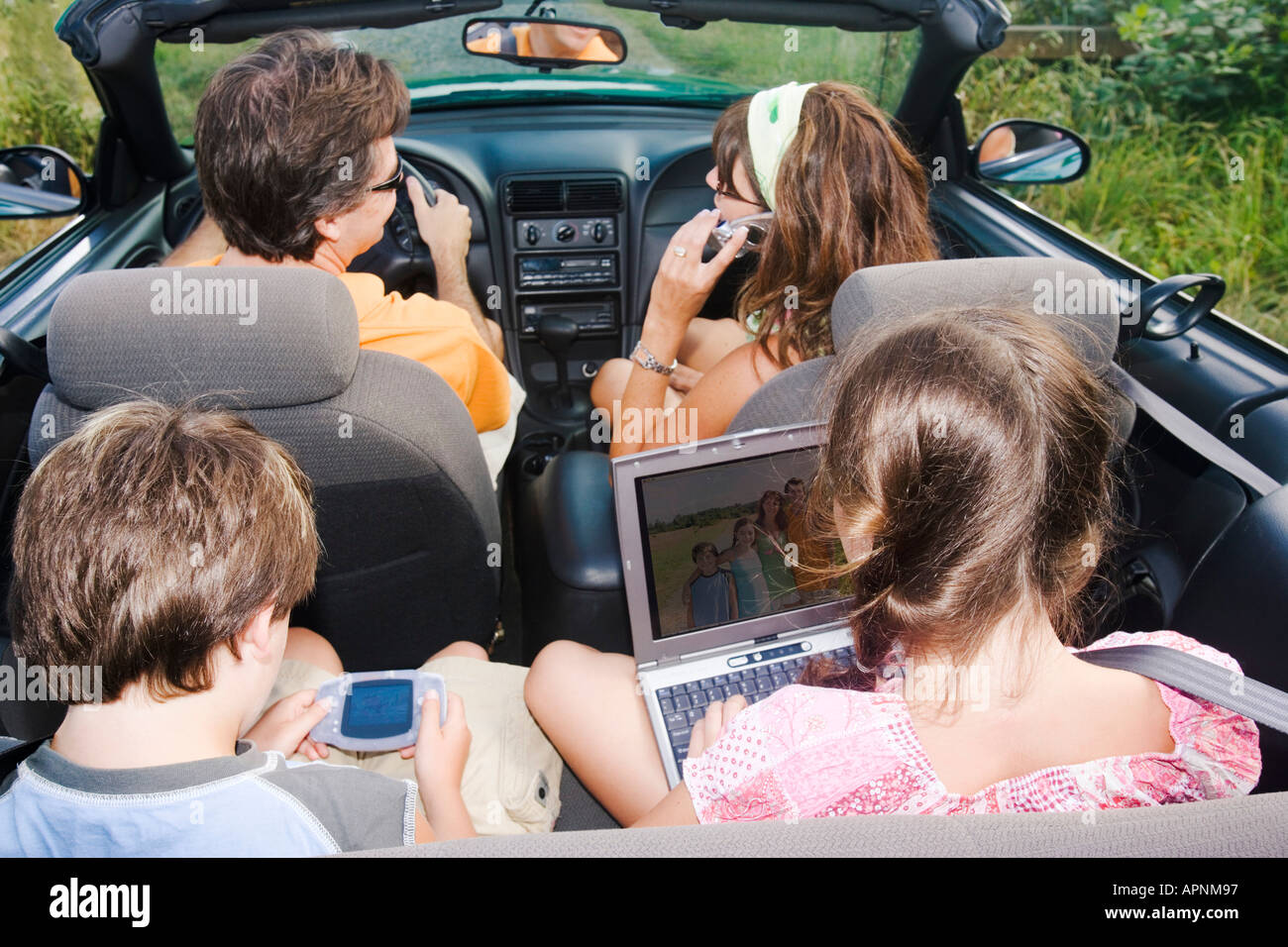 Familie im Cabrio mit tragbare Elektronik Stockfoto