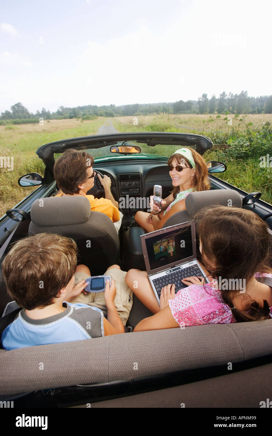 Familie im Cabrio mit tragbare Elektronik Stockfoto