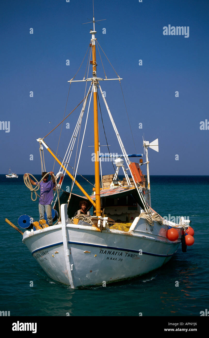 Ein Mann, ein Seil auf dem Vordeck ein Fischerboot im Hafen von Diafani im Nord-Osten der Insel Karpathos-wickeln Stockfoto