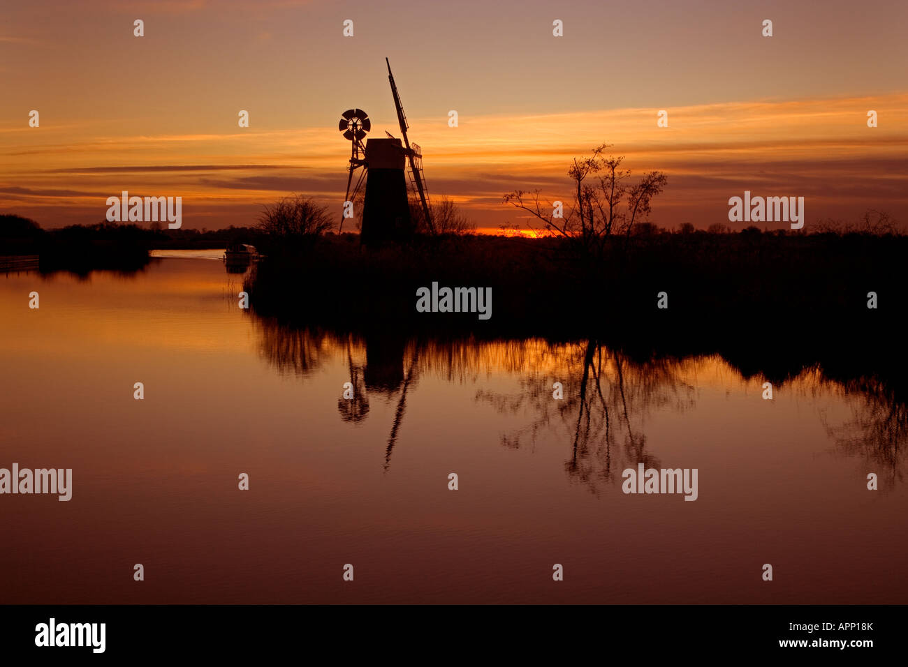 Turf Moor Entwässerung Mühle Silhouette gegen einen Sonnenuntergang auf dem Fluss Ant an wie Hill Norfolk Broads in einem Winter Sonnenuntergang Stockfoto