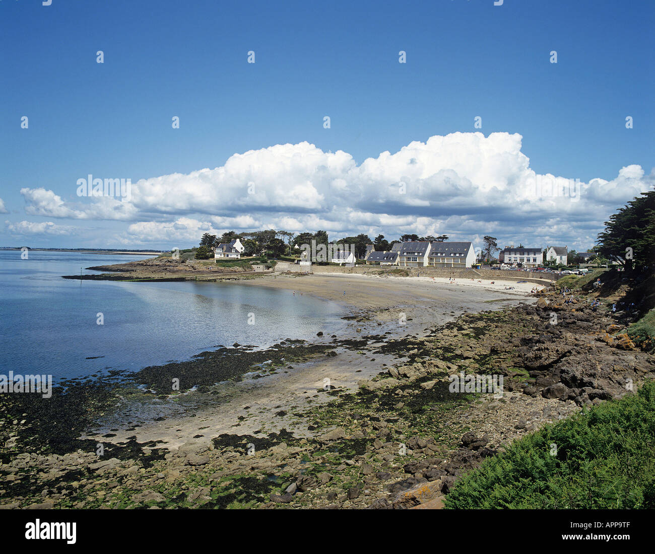 Die kleine Sandbucht am Port Navalo mit Häuser inmitten von Bäumen auf der landseitigen darüber hinaus auf der Rhuis Halbinsel Stockfoto