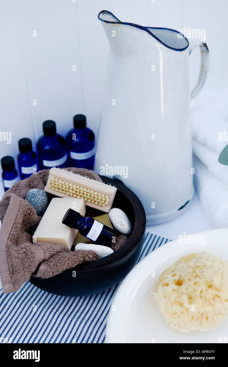 Spa-Badezimmer-Einstellung: Aromatherapie Öle, Vintage Emaille Kanne, Flanell, Holzschale mit Wasser gefüllt und Naturschwamm Stockfoto
