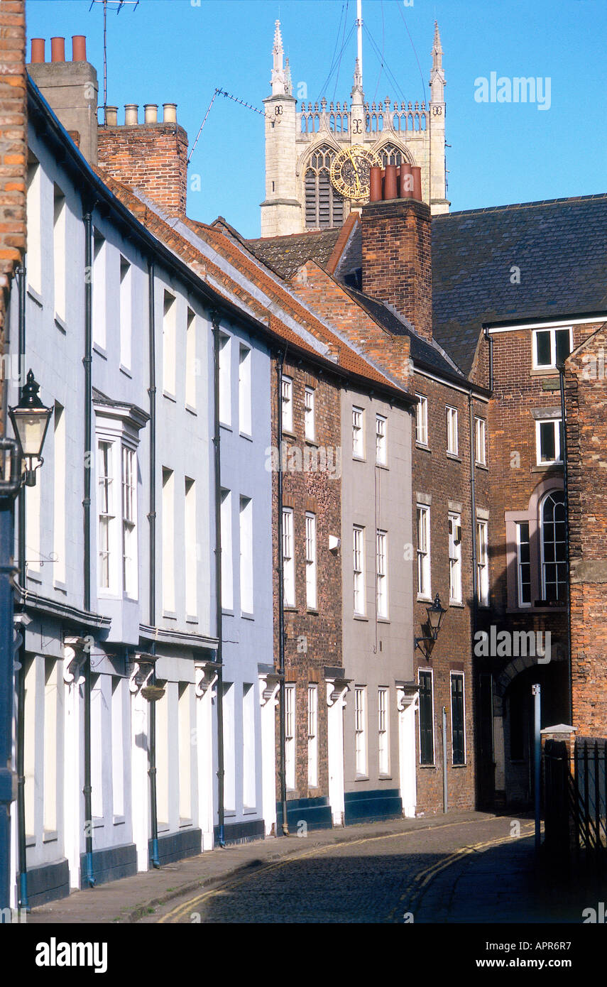 Eine Straße über drei geschossiges Reihenhaus befindet sich im Rumpf, die Altstadt von der pinnacled Turm aus dem 14. Jahrhundert Kirche der Heiligen Dreifaltigkeit übersehen wird, die auf dem Marktplatz steht Stockfoto