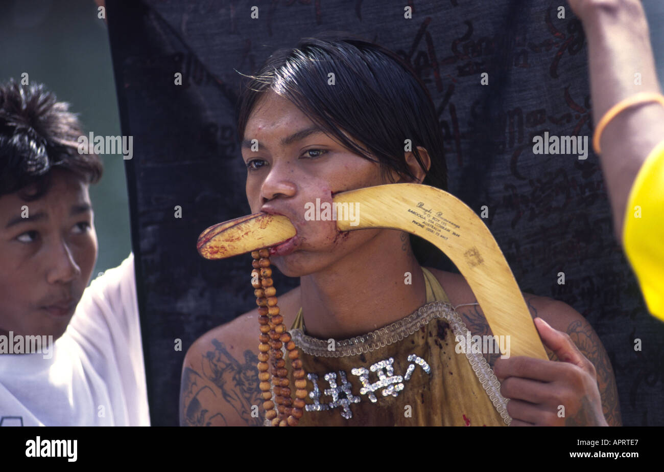 Geist-Medium mit einem Bumerang durch seine Wange während Vegetarian Festival in Phuket Thailand Stockfoto