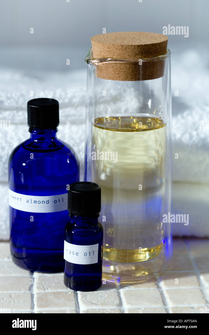 Blauen Glasbehältern ätherischen Ölen gefüllt mit Bio-Ölen mit einem Glas süße Mandel Öl gegen eine weiße Baumwolle t erschossen Stockfoto